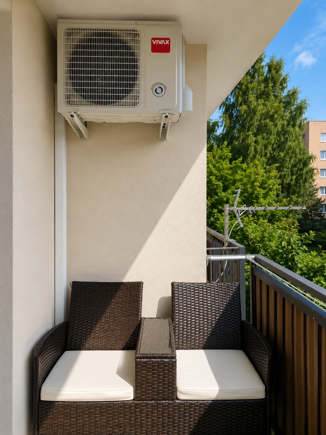 Jednostka zewnętrzna klimatyzatora zawieszona na wspornikach na balkonie.